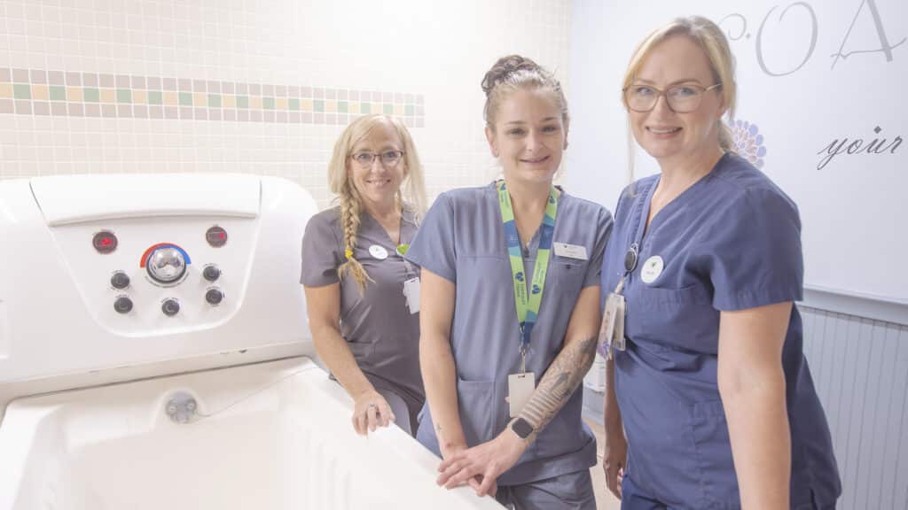 A group of Fairmount staff next to a hydrotheraphy bathtub.