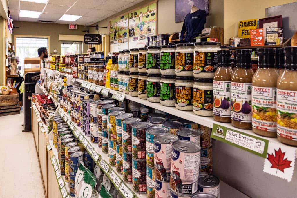 A long line of jars and cans in a retail store.